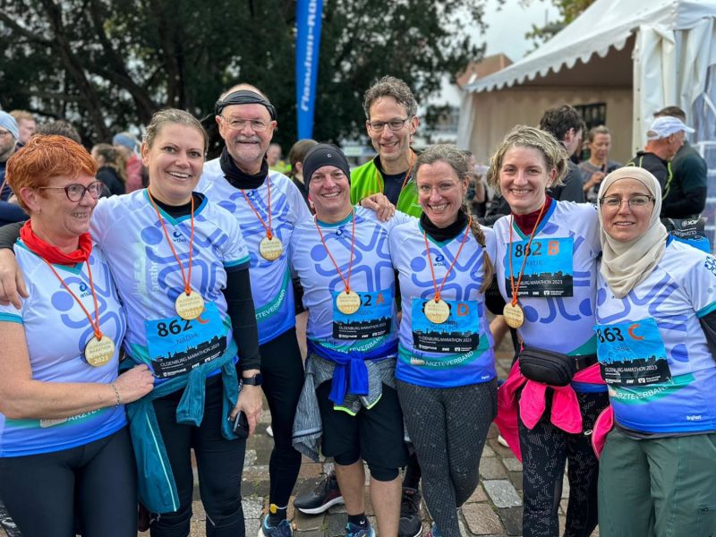 Bild aus dem Zieleinlauf von den teilnehmenden "LAUFärzteverbänden" in speziellen Trikots zusammen mit Prof. Freitag von der Uni Oldenburg.